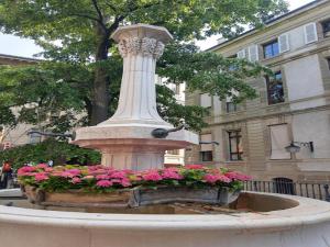 a statue with flowers in a fountain in front of a building at Cozy Apartment With Mountain Views in Veysonnaz