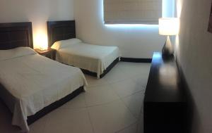 Cette chambre comprend 2 lits et une fenêtre. dans l'établissement Bay View Grand Marina Condo 1004S, à Ixtapa