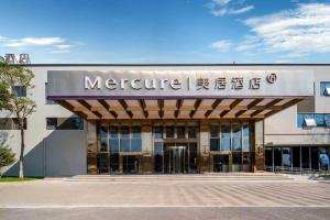 a large building with a sign on the front of it at Mercure KunMing Airport in Kunming