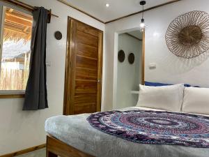 a bedroom with a bed and a wooden door at Sunset Garden in San Vicente