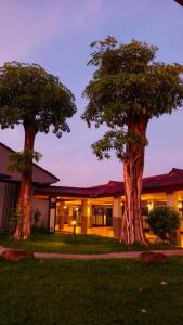 two trees in front of a building at Eastpana 304 R2 Hotel in Si Maha Phot