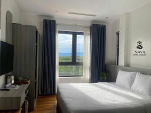 a bedroom with a bed and a large window at Nava Hotel & Resort in Dong Hoi