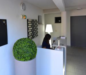 une femme assise à un bureau dans un bureau dans l'établissement Les Terrasses Du Grand Large, à Porto Pollo