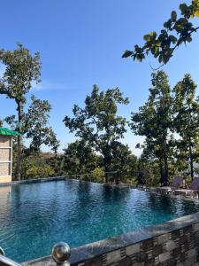 a large swimming pool with trees in the background at Orchards Suites Lansdowne in Lansdowne