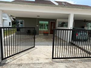 a black fence in front of a house at Teratak Shamar in Kampong Tebok Pulai