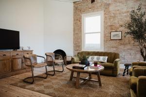 a living room with a couch and chairs and a table at Blacksmith House on Main in Tocumwal