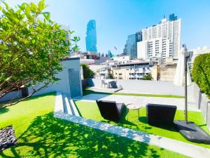 a view from the roof of a building with chairs and grass at The Quarter Silom by UHG in Bangkok
