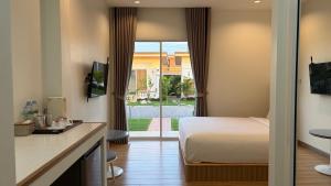 a hotel room with a bed and a sliding glass door at HomeGate Resort in Prachuap Khiri Khan