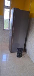 a stainless steel refrigerator in a room with a trash can at CLAUDIA Blessings in Saint Gabriel