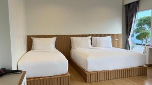 two beds sitting next to each other in a room at HomeGate Resort in Prachuap Khiri Khan