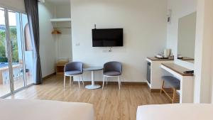 a room with a table and two chairs and a tv at HomeGate Resort in Prachuap Khiri Khan