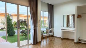 a bedroom with a table and chairs in a room with sliding glass doors at HomeGate Resort in Prachuap Khiri Khan