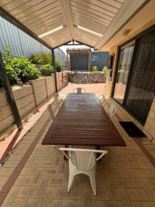 a wooden table and chairs on a patio at Hibiscus Haven in Eaton