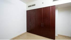 a room with wooden cabinets in a white wall at Devine Holidays JBR in Dubai