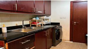 a kitchen with a sink and a washing machine at Devine Holidays JBR in Dubai