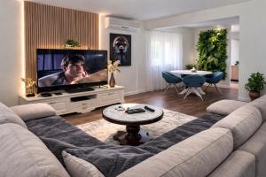 a living room with a couch and a flat screen tv at Villa Aqua Vista in Mostar