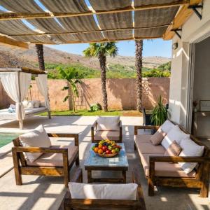 a patio with chairs and a table with a bowl of fruit at Villa Aqua Vista in Mostar