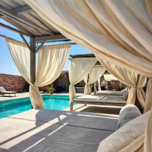 a bed with curtains over it next to a swimming pool at Villa Aqua Vista in Mostar