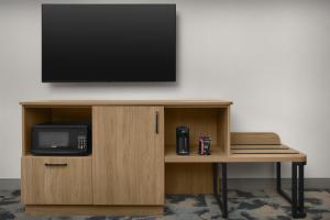 a flat screen tv on top of a wooden entertainment center at Hampton Inn & Suites Phoenix Glendale-Westgate in Glendale
