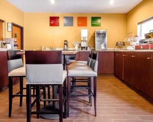 a restaurant with a bar with chairs and a kitchen at Comfort Suites Louisville East in Douglass Hills