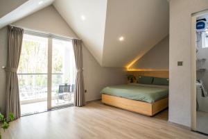a bedroom with a bed and a large window at Dahill 196 Dalat in Da Lat