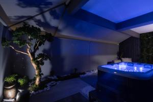 a room with a tub with a tree in it at Edem in Larisa