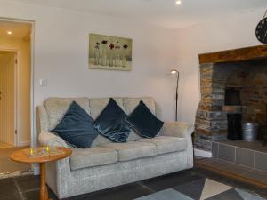 a couch with pillows in a living room with a fireplace at Uk47757 - Rose Cottage in Launceston