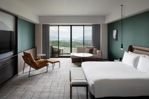 a hotel room with a bed and a living room at Fuji Speedway Hotel, in The Unbound Collection by Hyatt in Oyama