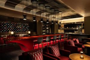 a bar in a restaurant with red chairs and wine bottles at Fuji Speedway Hotel, in The Unbound Collection by Hyatt in Oyama