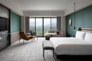 a hotel room with a bed and a living room at Fuji Speedway Hotel, in The Unbound Collection by Hyatt in Oyama