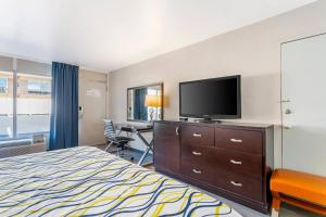 a hotel room with a bed and a flat screen tv at Rodeway Inn Orange Park - Jacksonville near Naval Air Station in Orange Park
