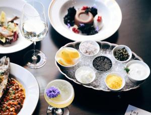 a table with plates of food and glasses of wine at Hotel Savoy Kansas City, Tapestry Collection by Hilton in Kansas City