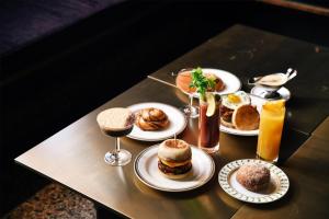 a table topped with plates of food and drinks at Hotel Savoy Kansas City, Tapestry Collection by Hilton in Kansas City