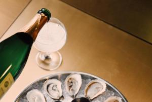 a bottle of champagne next to a plate of oysters at Hotel Savoy Kansas City, Tapestry Collection by Hilton in Kansas City +58 photos