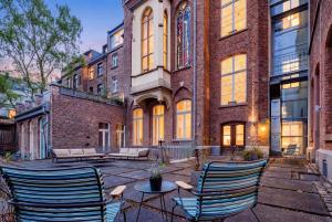 a patio with chairs and a table in front of a building at Hopper Hotel St. Josef, WorldHotels Crafted in Cologne