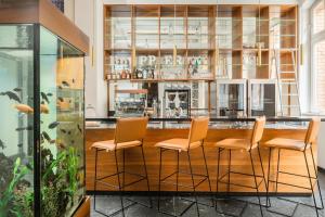 a bar with orange stools in a room at Hopper Hotel St. Josef, WorldHotels Crafted in Cologne