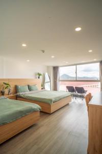 two beds in a bedroom with a large window at Dahill 196 Dalat in Da Lat
