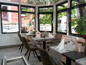 a restaurant with tables and chairs and windows at Pension Weserblick in Bremen