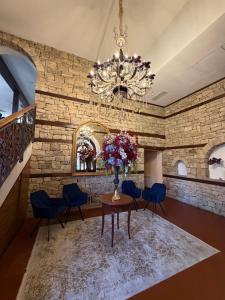 a room with a table and blue chairs and a chandelier at A&N Residence Bolyarka in Arbanasi