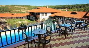 a balcony with tables and chairs next to a pool at A&N Residence Bolyarka in Arbanasi