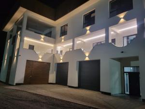 a building with two garage doors and lights on it at Gosen Grand Residence in Sângeorz-Băi