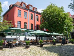 people sitting at tables in front of a building at Pension Weserblick in Bremen