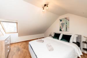 a bedroom with a large white bed and a window at Sunset Stay Pärnu in Pärnu
