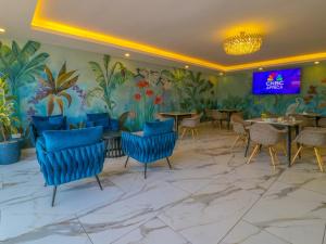 a restaurant with blue chairs and a mural of plants at Yaya Hotel & Apartments in Nairobi
