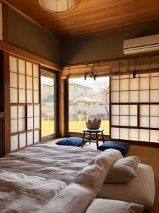 a large bed in a room with windows at 宿杏 Yado Ann in Kofu