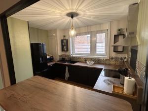 a kitchen with a table and a sink and a window at Lestandardgravelines in Gravelines