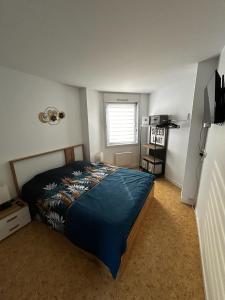 a bedroom with a bed with a blue blanket at Lestandardgravelines in Gravelines