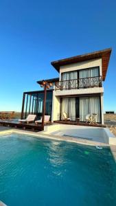 a house with a large pool of water in front of it at Vila Cangalha in Camocim