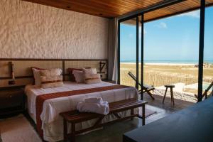 a bedroom with a bed and a view of the beach at Vila Cangalha in Camocim +177 photos