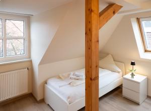 a small attic bedroom with a bed and a ladder at Pension Weserblick in Bremen